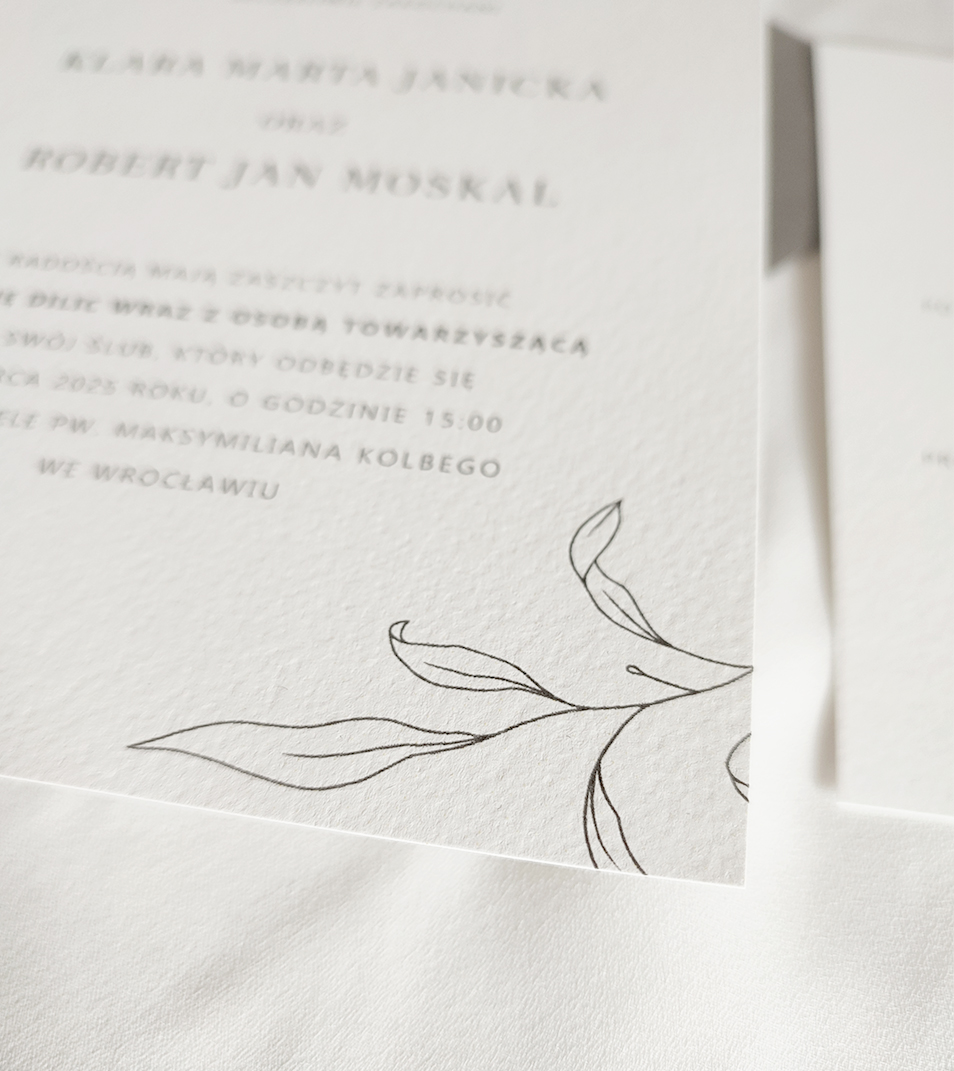 Minimalistyczne listki, pociągnięte linią na zaproszeniach ślubnych.