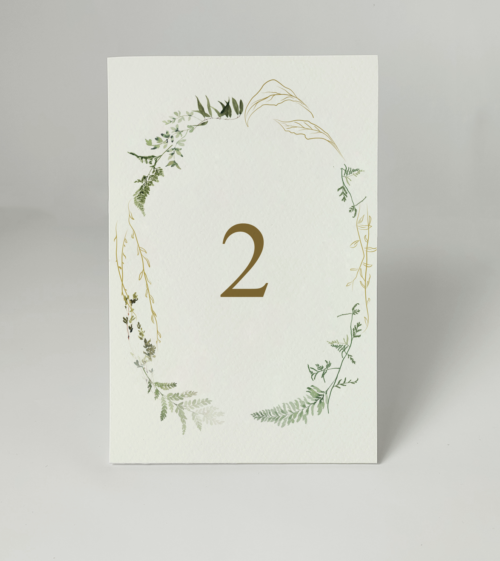 Minimalistyczne numerki na stół weselny z motywem paproci i zielonymi detalami.