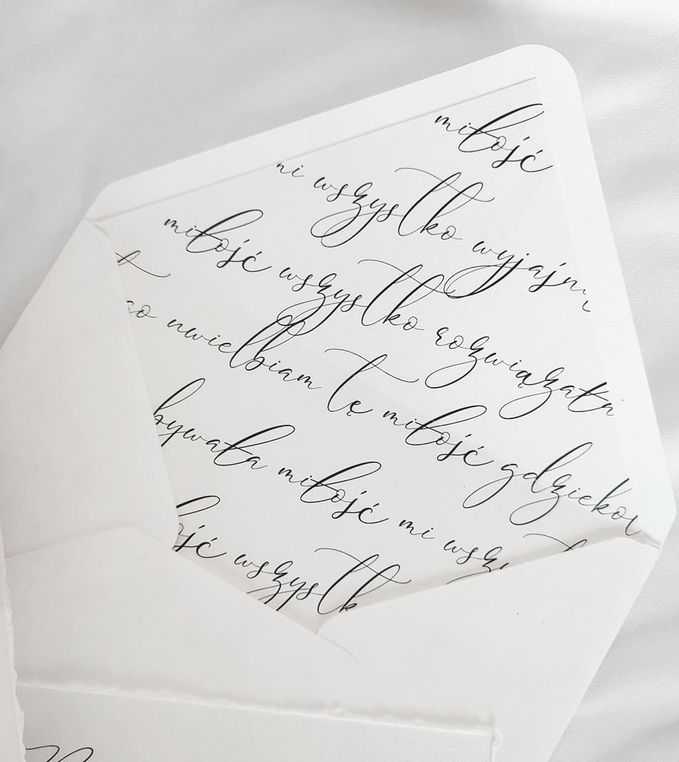 Biała koperta z miłośnym cytatem. Zastosowana została kaligrafia.