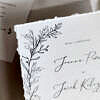 Ręcznie rysowane listki na zaproszeniu ślubnym.