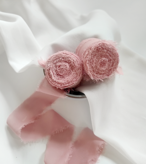 Różowa, brudny róż wstążka szyfonowa, jedbwabna z postrzepionymi brzegami. Pięknie udekoruje zaproszenia ślubne.